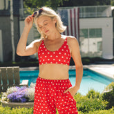 Woman wearing the red Star Rise Bikini Top beside a swimming pool