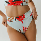 Close-up front view of Sea Glass Almost Cheeky Bottoms with a light blue floral print and cheeky fit