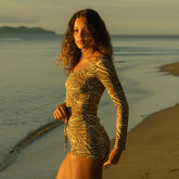 Side view of desert camo boy shorts showcasing the patterned fabric on a model with a beach background