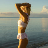Side-back view of Lavender Houndstooth Bella Crop Top showcasing ruffled straps with an ocean background