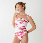 Three-quarter view of Villa Almost Cheeky Bottoms with white floral print and cheeky fit on a model in a light gray studio