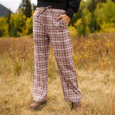 Front view of Audrey Trouser in Toffee Plaid showcasing drawstring waist and side pockets on a model in an autumn field