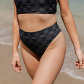 Front view of Slate Check Almost Cheeky Bottoms showcasing a slate check pattern on a model at the beach