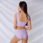 Rear view of periwinkle high-waisted bottoms showcasing the high-waisted fit on a model against a light backdrop