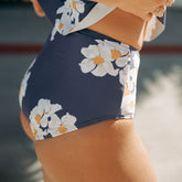 Close-up side view of Daisy High-Waisted Bottoms showcasing a navy floral print and high waist on a model