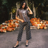 Front view of Spooky Audrey mid-rise wide-leg pants in a bat print, worn by a model outdoors