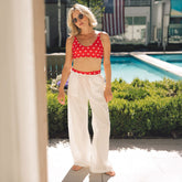 Front view of Rise Bikini Top in red star print showcasing its scoop neckline and fitted style with a poolside background