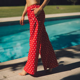 Side view of Slip On Trouser Star showcasing red wide leg pants with white stars beside a swimming pool
