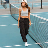 Front view of black Jetsetter Cargo Joggers showcasing cargo pockets and relaxed fit on model with a tennis court background