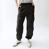 Front view of black Jetsetter Cargo Joggers showcasing cargo pockets and cuffed ankles on a model against a white background