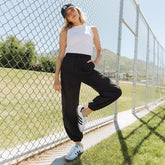 Front view of black Jetsetter Cargo Joggers showcasing cargo pockets, drawstring waist, and jogger cuffs at a tennis court