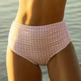 Close-up front view of lavender houndstooth ruched midi bottoms on a model against a waterfront background