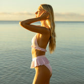 Side view of lavender houndstooth triangle bikini top showcasing ruffled band on a model at the beach
