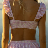 Back view of Lavender Houndstooth Bella Crop Top showcasing ruffled straps and cropped fit on a model in warm outdoor light