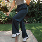 Angled view of Audrey Trouser in Heather Cobalt showcasing wide-leg fit and drawstring waist on a model outdoors