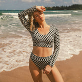 Front view of Kona Almost Cheeky Bottoms showcasing a black and white geometric pattern on a model at the beach