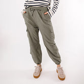 Front view of olive Jetsetter Cargo Joggers with cargo pockets and elastic cuffs on a model against white