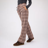 Side view of Audrey Trouser in Toffee Plaid showcasing wide legs and drawstring waist on a model against a light background