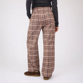 Rear view of Audrey Trouser showcasing toffee plaid pattern and wide-leg fit on a model against a light studio background