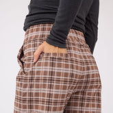 Close-up rear view of Audrey Trouser in Toffee Plaid showcasing a back pocket and hand against a light background