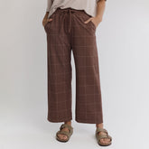 Front view of Audrey Mid Rise Wide Leg Pants in brown and cream windowpane, showing wide legs, drawstring waist and pockets