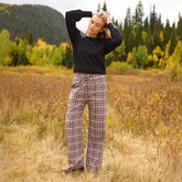 Front view of Audrey Trouser in toffee plaid showcasing the plaid pattern on a model in a field