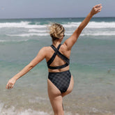 Rear view of Slate Check Almost Cheeky Bottoms showcasing slate check pattern and cheeky fit on model at the beach