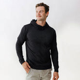 Front view of men’s black travel hoodie showcasing its cowl neck and long sleeves with a light studio background
