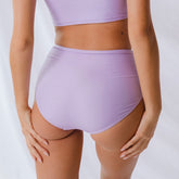 Back view of periwinkle high-waisted bottoms showcasing the high-rise fit on a model against a light background