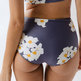 Rear view of Daisy High-Waisted Bottoms showcasing white floral print on a navy background worn by a model